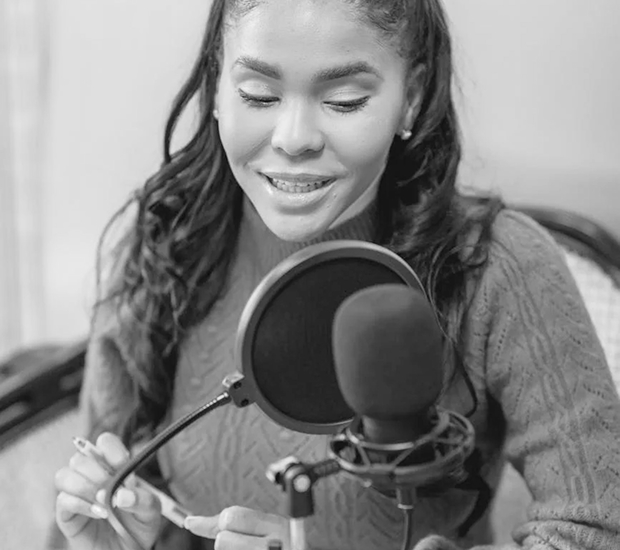 a woman is talking through a mic