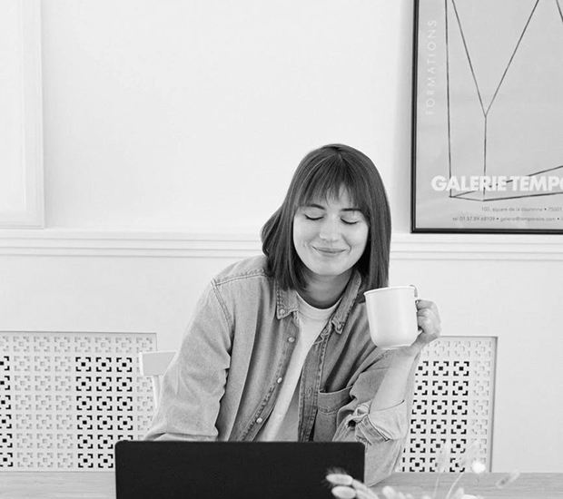 a woman is drinking coffee while working
